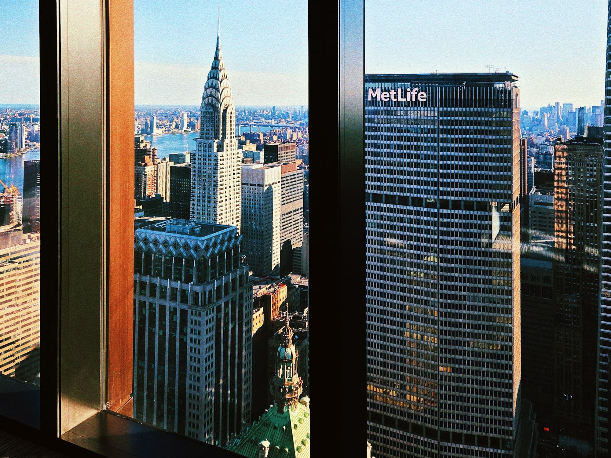 View from a high-floor Manhattan office window onto the Chrysler Building and dense midtown skyscrapers